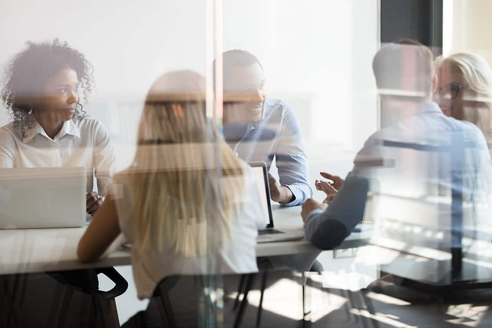 Teammeeting in einem modernen Büro, mehrere Personen diskutieren gemeinsam